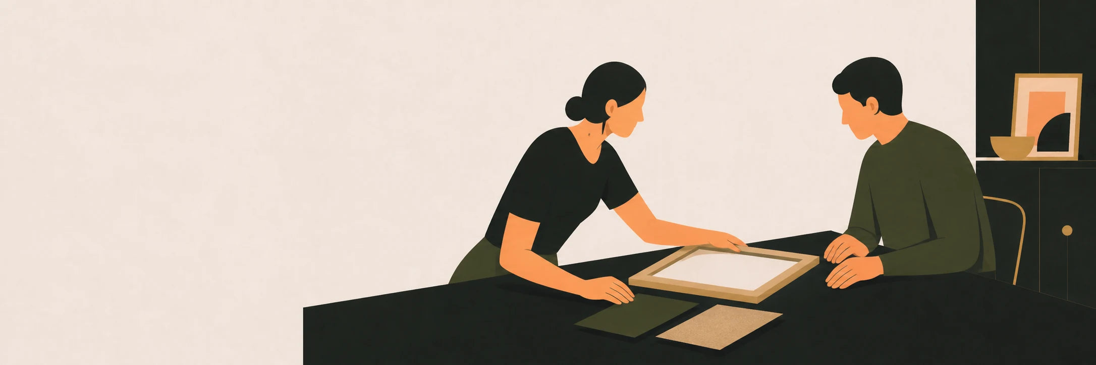 Two people considering a frame and material samples at a table